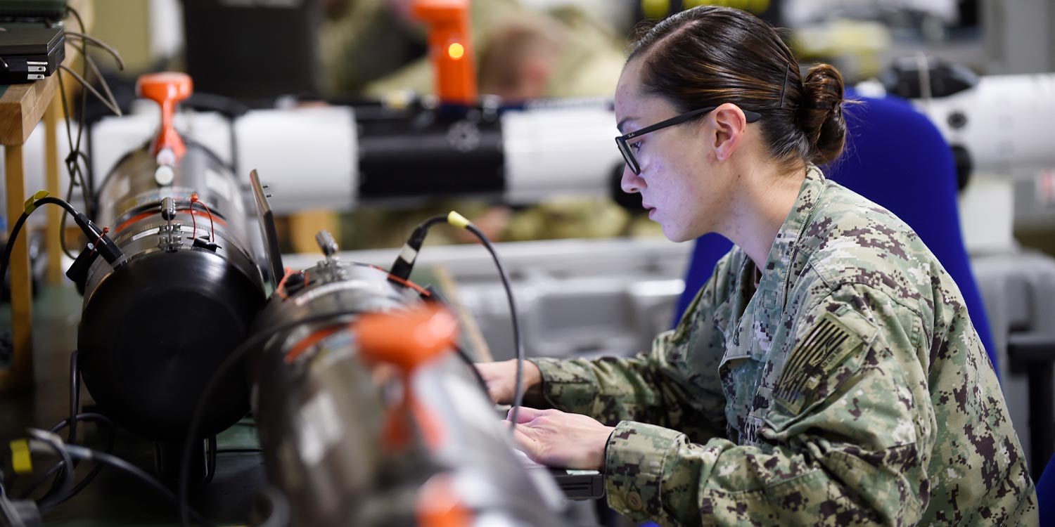 Office of Naval Research researcher works to reprogram an unmanned vehicle prior to testing.